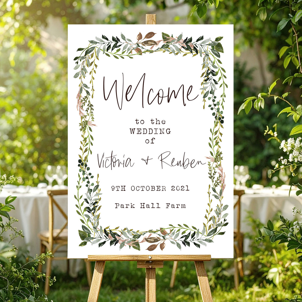 Wedding welcome sign with green foliage border in a garden setting