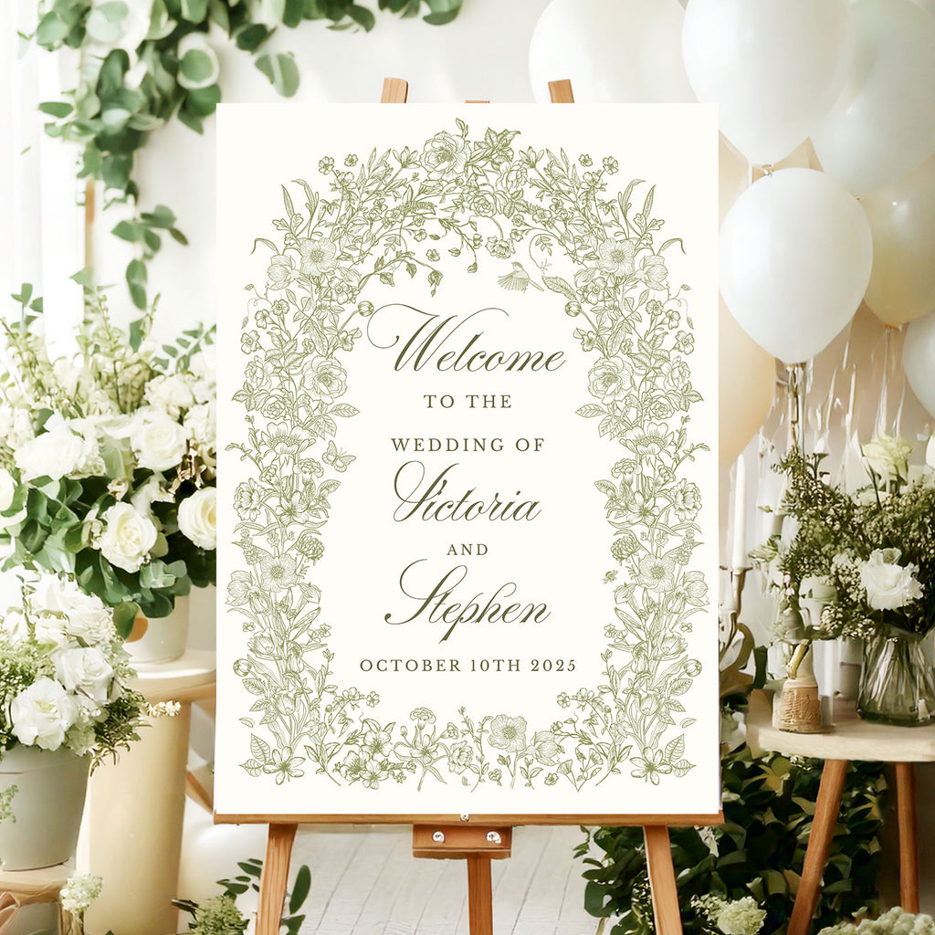 wedding welcome sign featuring green foliage and wildflowers in a floral arch around the elegant text