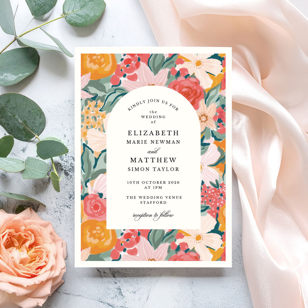 wedding invitation with peach, coral and pink flowers surrounding an arch frame