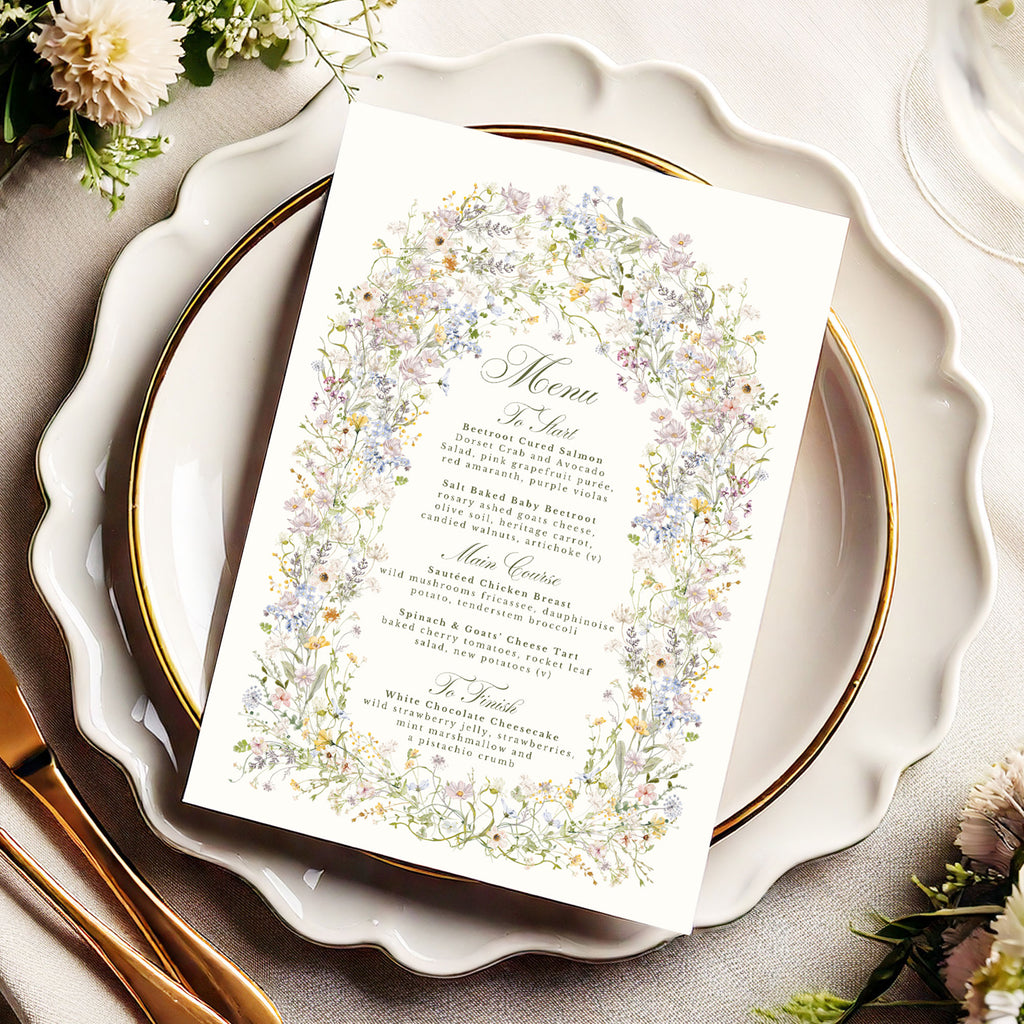 wedding menu with a pastel wildflower arch